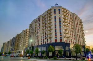 a large tall building with many windows on a street at Nordic Style Apartment in Fergana