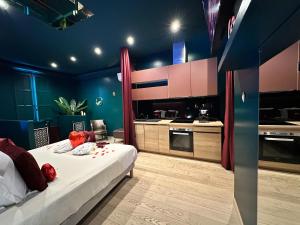 a bedroom with a large bed and a kitchen at Mieuxqualhotel jacuzzi privatif Velvet Desire in Bordeaux