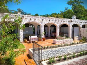 a stone house with a patio and a garden at Casa de campo con piscina, bar y casa de huéspedes in Maldonado