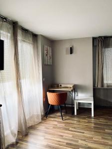 a room with a desk and a table and curtains at Brit Hotel Le Surcouf in Saint Malo