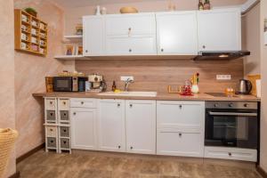 Una cocina con gabinetes blancos y un fregadero. en Tarnovo Nest | Cozy 1BR Apartment, en Veliko Tŭrnovo