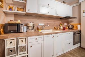 Una cocina con gabinetes blancos y un microondas. en Tarnovo Nest | Cozy 1BR Apartment, en Veliko Tŭrnovo