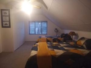 ein Schlafzimmer mit drei Betten im Dachgeschoss in der Unterkunft AtPeace in Ifafa Beach