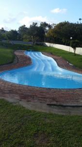 a swimming pool with blue water in a park at AtPeace in Ifafa Beach