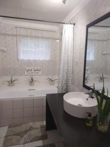 a bathroom with a sink and a tub and a mirror at AtPeace in Ifafa Beach