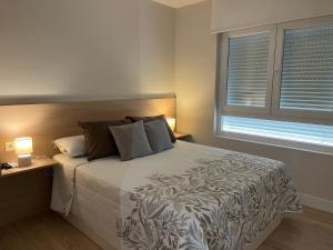 sypialnia z dużym łóżkiem i dwoma oknami w obiekcie Astorga suites w mieście Astorga