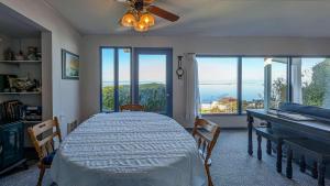 a bedroom with a bed and a desk and windows at PA Crows Nest Cottage in Port Angeles