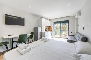 ein weißes Wohnzimmer mit einer Couch und einem Tisch in der Unterkunft Studio Mare Blu by PS in Golem