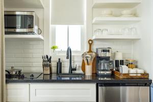 a kitchen with a black counter top with a microwave at Endless Summer Pool Club at Mahogany Bay Unit C in San Pedro