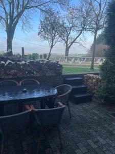 a table and chairs in a yard with a stone wall at Valley View Cottage 4 Authentic 6 guest cottage near Valkenburg in Voerendaal +9 photos