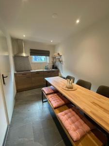 a kitchen with a wooden table with cushioned chairs at Valley View Cottage 4 Authentic 6 guest cottage near Valkenburg in Voerendaal