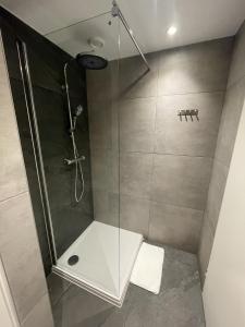 a bathroom with a shower with a glass door at 17 4p Historical Cottage near Valkenburg in Voerendaal