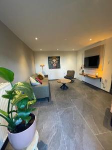 a living room with a couch and a potted plant at Valley View Cottage 4 Authentic 6 guest cottage near Valkenburg in Voerendaal