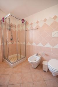 une salle de bain avec une douche, des toilettes et un lavabo dans l'établissement Attico vista mare Caletta sul mare, à La Caletta 12 autres photos