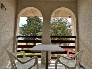 a table and two chairs in front of two windows at Maralfrente de Noja- 6020 in Noja
