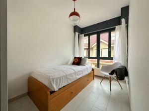 a bedroom with a bed and a window and a chair at Maralfrente de Noja- 6020 in Noja