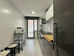 a white kitchen with a counter and a microwave at Maralfrente de Noja- 6020 in Noja