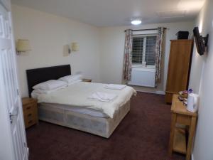 a small bedroom with a bed and a window at The Belfry Hotel in Little Dean