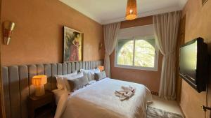a bedroom with a bed and a window and a television at Dar El Hana 4 Bedroom Villa in Marrakech +80 photos