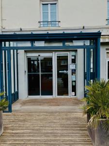 an entrance to a building with a wooden deck at Brit Hotel Le Surcouf in Saint Malo