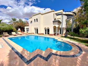 a swimming pool in front of a house at Dar El Hana 4 Bedroom Villa in Marrakech