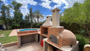 a brick oven is sitting next to a swimming pool at Dar El Hana 4 Bedroom Villa in Marrakech