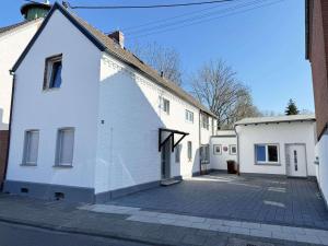 a white building with a driveway in front of it at Fabulous House in Wesseling in Wesseling
