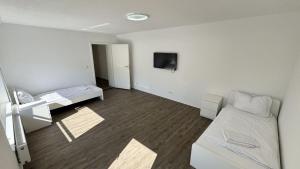 a room with two beds and a tv on the wall at Fabulous House in Wesseling in Wesseling