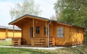 Cabaña de madera con puerta grande y ventanas en Camping Amerika, en Františkovy Lázně