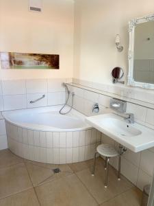 a white bathroom with a tub and a sink at Gasthof Die Krone in Schwäbisch Hall +77 photos
