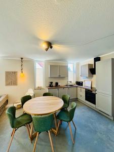 a kitchen with a wooden table and green chairs at Ferienwohnungen Maedchen in Wunstorf