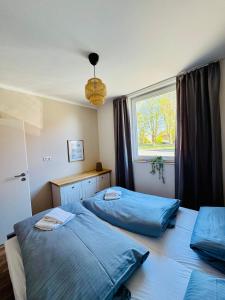 a bedroom with two beds and a window at Ferienwohnungen Maedchen in Wunstorf