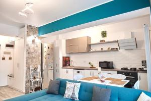 a living room with a blue couch and a kitchen at Gota Place between lake and sea in Mamaia