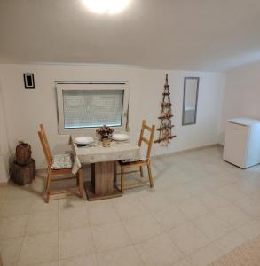 a dining room with a table and two chairs at Apartman Golubinka - Molat in Molat +47 photos