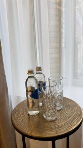 two bottles and glasses sitting on a table at EVA boutique apartments in Vilnius