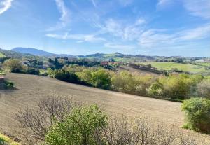 an open field with trees and mountains in the background at Casa Ilde in Ancona +4 photos