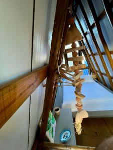 a wooden spiral staircase with a table and a bed at Pousada Quilombo do Tibau in Tibau