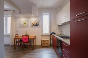 cocina con mesa y mesa de comedor en BED INN - Palazzo Urbe, en Olbia