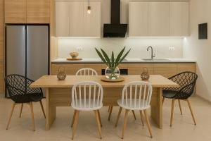 a kitchen with a wooden table and four chairs at Sound of Vitality, Luxury Stay Near the Sea and Gym in Agios Nikolaos +26 photos