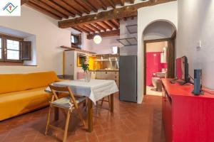 a living room with a table and a yellow couch at Casa Dei Briganti by TuscanyWeGo in Massa