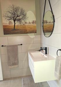 a bathroom with a white sink and a mirror at Nature's Nest in Bettyʼs Bay
