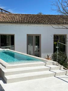 a white house with a swimming pool and stairs at Amazing suite by the fair in Valencia