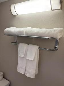 a bathroom with white towels hanging on a rack at Days Inn by Wyndham West Branch Iowa City Area in West Branch