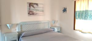 a bedroom with a bed and two tables and a mirror at Sardegna Top Golfo Di Marinella in Golfo Aranci +287 photos
