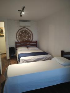 a bedroom with two beds and a wall at Pousada Capitão in Barra do Sirinhaém +17 photos