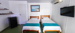 2 letti in una camera con TV a schermo piatto di Sarie Bay Inn a San Andrés