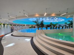 a large swimming pool in a building with stairs at Hanza Tower GOLD-21 Deluxe 63m2 with Pool & Spa in Szczecin
