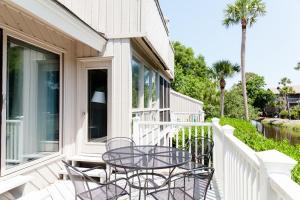 Un patio con una mesa y sillas en un balcón. en Racquet Club 10 by Wild Dunes, in Resort Core, en Isle of Palms