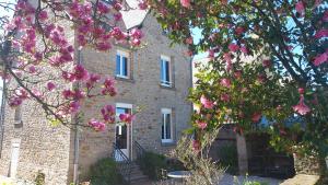 a brick building with pink flowers in front of it at La Villa d'Armel in Ploërmel