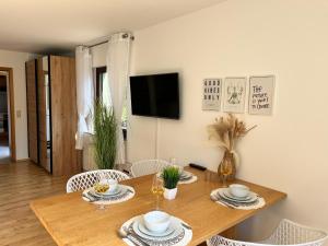DeißlingenにあるWohnung IDA ruhig, modern mit Parkplatz bei RW und VSの木製のテーブルと椅子のあるダイニングルーム